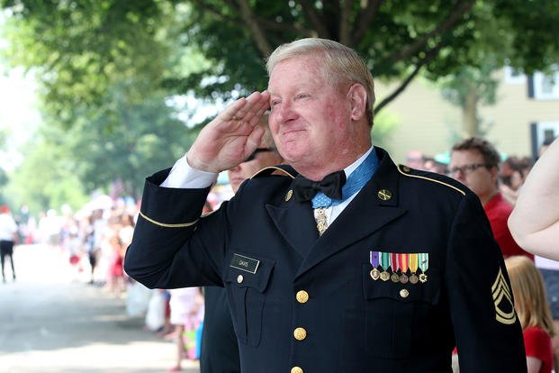 Medal of Honor recipient and retired U.S. Army Sgt. 1st Class Sammy Lee Davis renders a salute to a passing U.S. flag during the Independence Day parade at Arlington Heights, Ill.