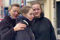 People mourn at the site of stabbing attack in Villach, Austria.